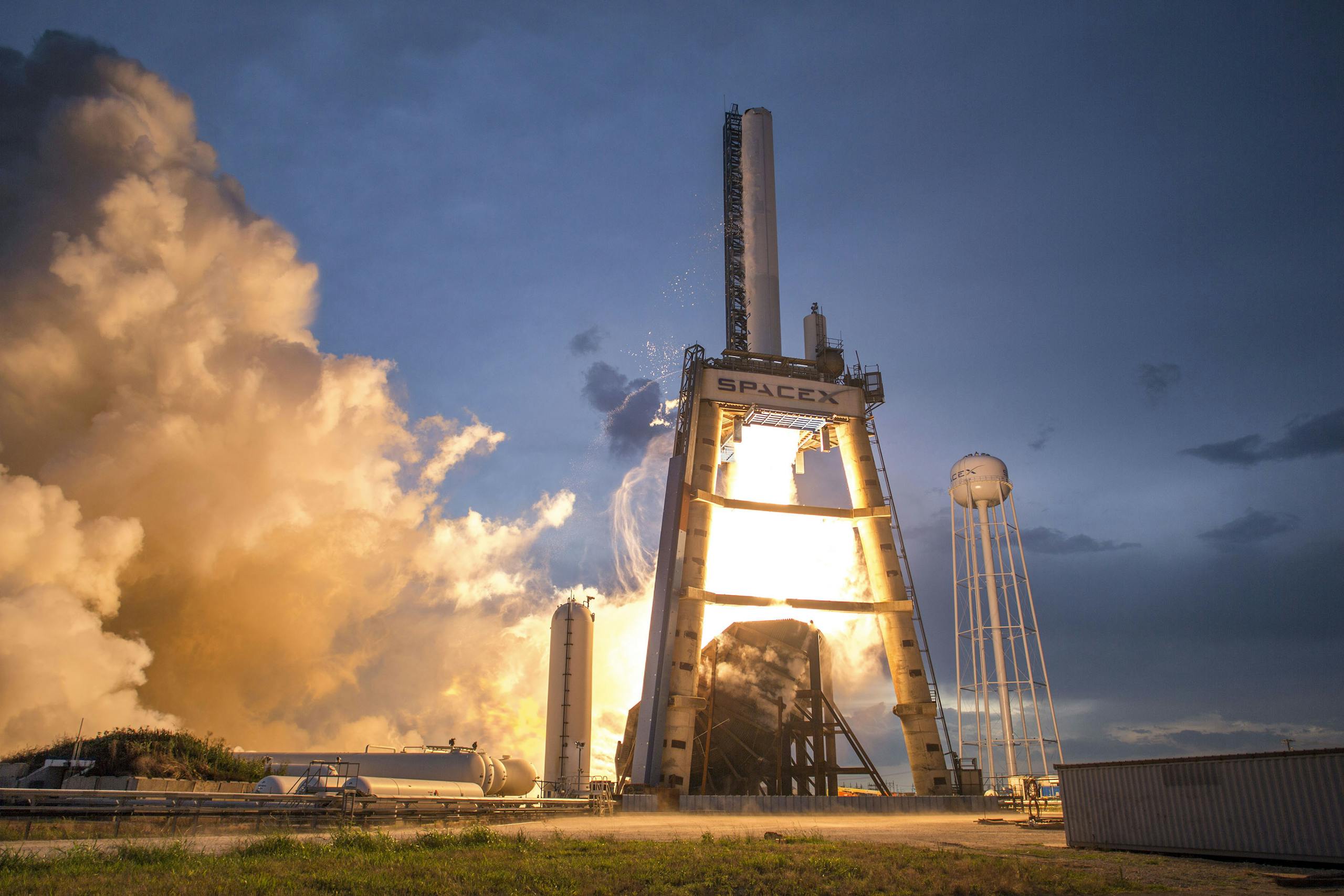 A dramatic shot of a SpaceX rocket launch against a colorful dusk sky, depicting power and technology.